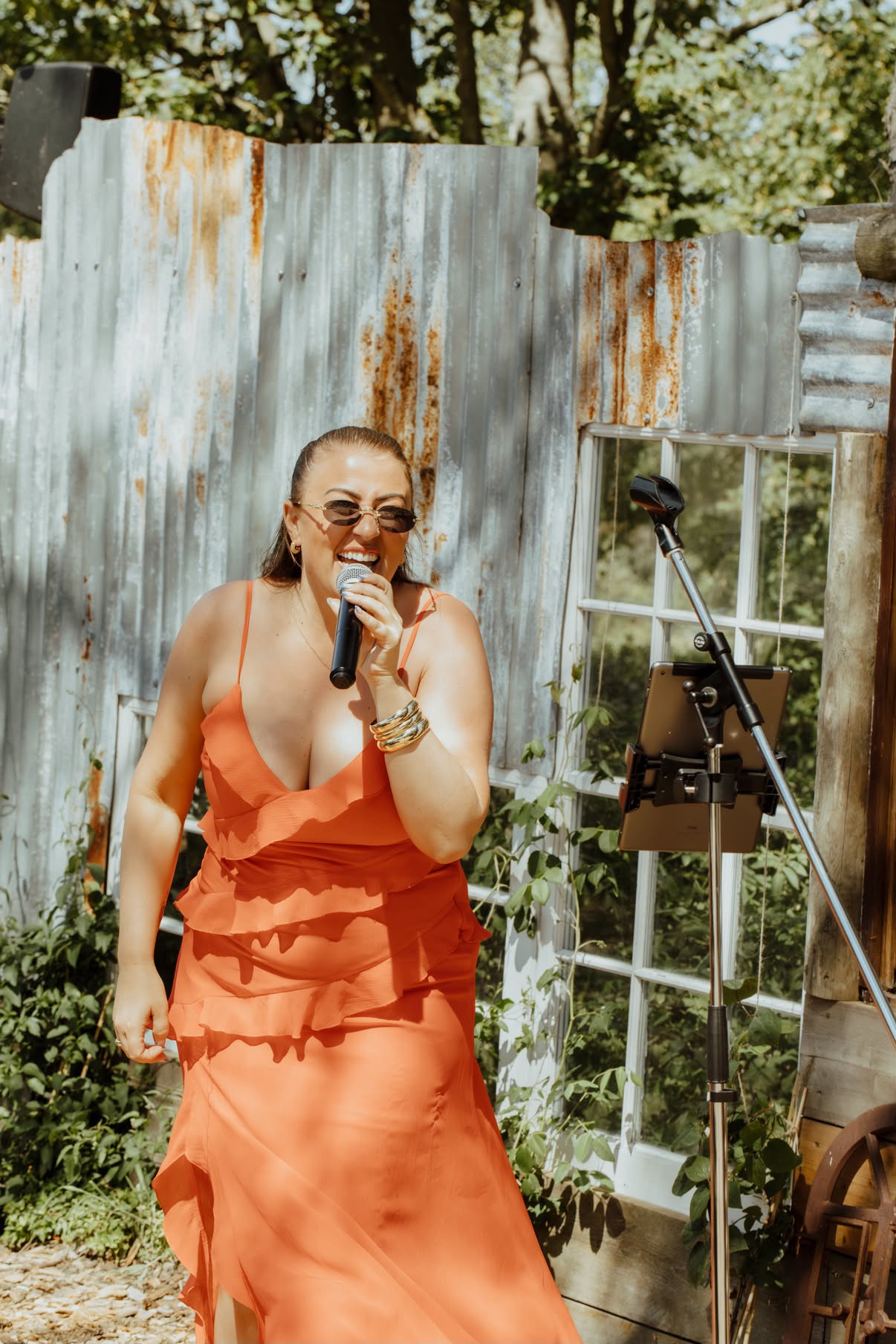 Emma Bennett singing outdoors in an orange dress