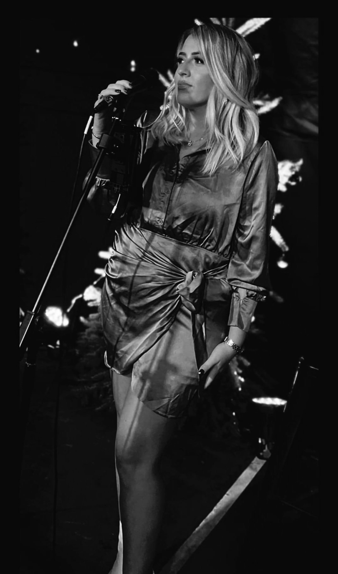 Emma Bennett performing on stage in black and white